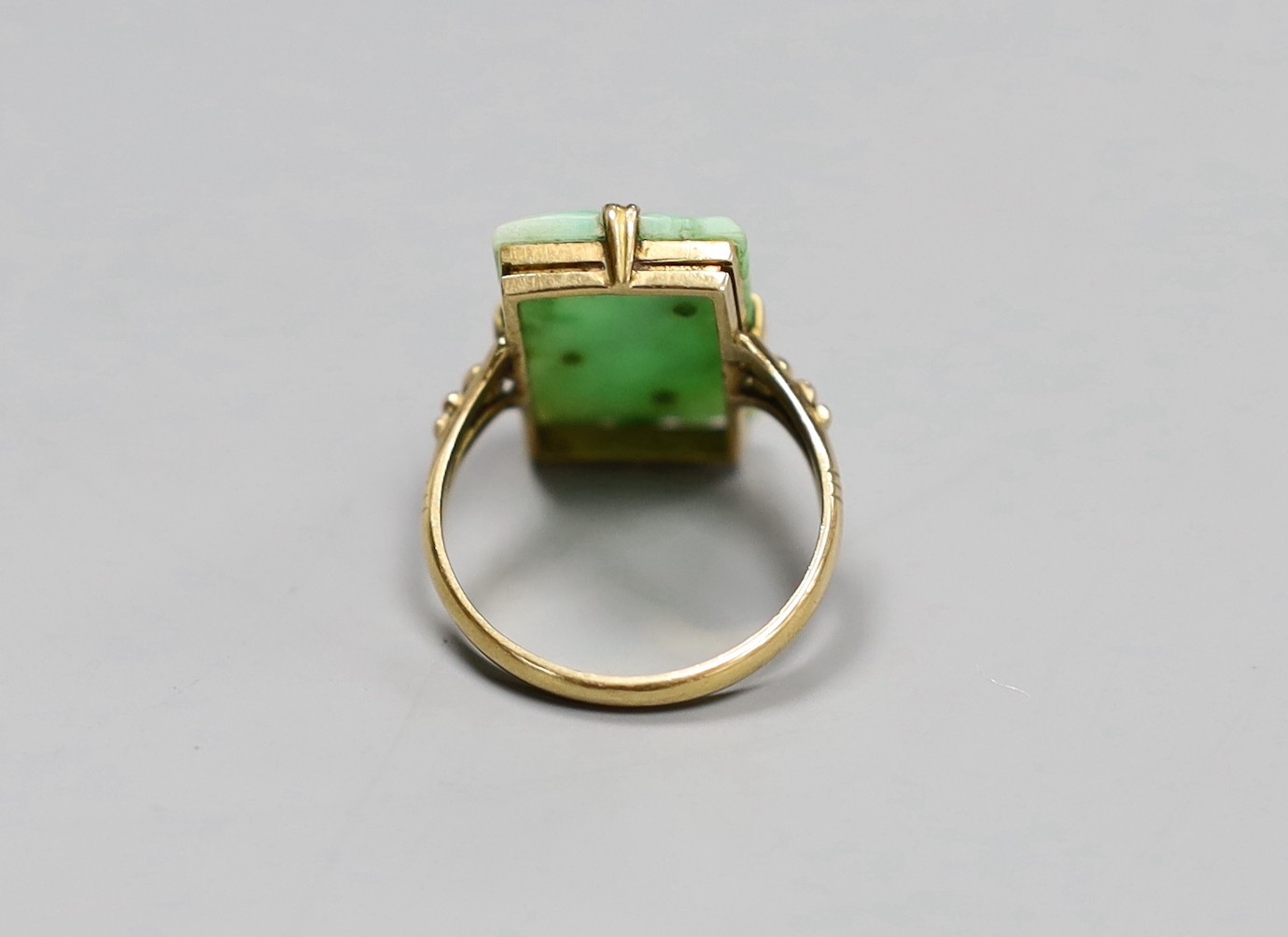 An early 20th century yellow metal Chinese jade plaque ring, size M, gross 4.8 grams